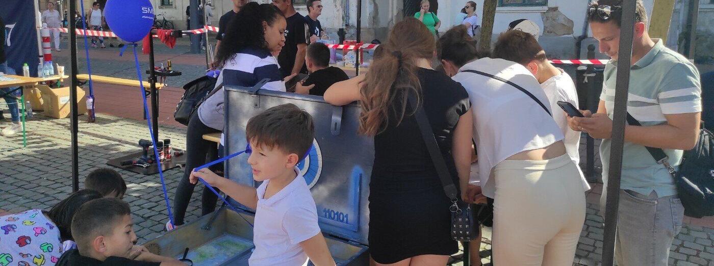 Copii la o activitate educațională Code2Connect într-un eveniment outdoor